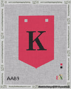 A taped needlepoint canvas with the design: Banner 18 mesh count Pointed K Black on Red.