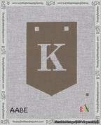 A taped needlepoint canvas with the design: Banner 18 mesh count Pointed K White on Brown.