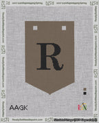 A taped needlepoint canvas with the design: Banner 18 mesh count Pointed R Black on Brown.
