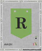 A taped needlepoint canvas with the design: Banner 18 mesh count Pointed R Black on Light Green.