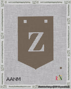 A taped needlepoint canvas with the design: Banner 18 mesh count Pointed Z White on Brown.