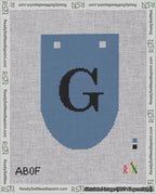 A taped needlepoint canvas with the design: Banner 18 mesh count Rounded G Black on Blue.