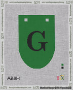 A taped needlepoint canvas with the design: Banner 18 mesh count Rounded G Black on Green.