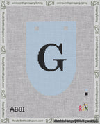 A taped needlepoint canvas with the design: Banner 18 mesh count Rounded G Black on Light Blue.