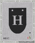 A taped needlepoint canvas with the design: Banner 18 mesh count Rounded H White on Black.