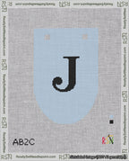 A taped needlepoint canvas with the design: Banner 18 mesh count Rounded J Black on Light Blue.