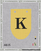 A taped needlepoint canvas with the design: Banner 18 mesh count Rounded K Black on Yellow.