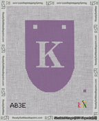 A taped needlepoint canvas with the design: Banner 18 mesh count Rounded K White on Purple.