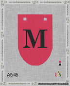 A taped needlepoint canvas with the design: Banner 18 mesh count Rounded M Black on Red.