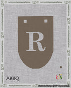 A taped needlepoint canvas with the design: Banner 18 mesh count Rounded R White on Brown.