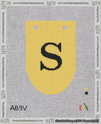 A taped needlepoint canvas with the design: Banner 18 mesh count Rounded S Black on Yellow.