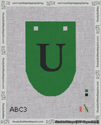 A taped needlepoint canvas with the design: Banner 18 mesh count Rounded U Black on Green.