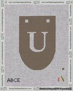 A taped needlepoint canvas with the design: Banner 18 mesh count Rounded U White on Brown.