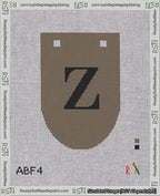 A taped needlepoint canvas with the design: Banner 18 mesh count Rounded Z Black on Brown.