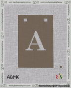 A taped needlepoint canvas with the design: Banner 18 mesh count Squared A White on Brown.