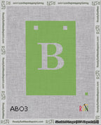 A taped needlepoint canvas with the design: Banner 18 mesh count Squared B White on Light Green.