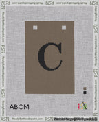 A taped needlepoint canvas with the design: Banner 18 mesh count Squared C Black on Brown.