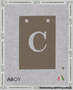 A taped needlepoint canvas with the design: Banner 18 mesh count Squared C White on Brown.