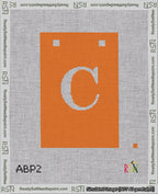 A taped needlepoint canvas with the design: Banner 18 mesh count Squared C White on Orange.