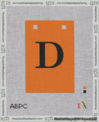 A taped needlepoint canvas with the design: Banner 18 mesh count Squared D Black on Orange.