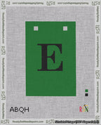 A taped needlepoint canvas with the design: Banner 18 mesh count Squared E Black on Green.