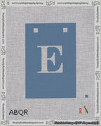 A taped needlepoint canvas with the design: Banner 18 mesh count Squared E White on Blue.