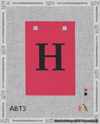 A taped needlepoint canvas with the design: Banner 18 mesh count Squared H Black on Red.