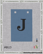 A taped needlepoint canvas with the design: Banner 18 mesh count Squared J Black on Blue.