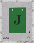 A taped needlepoint canvas with the design: Banner 18 mesh count Squared J Black on Green.