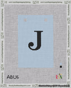 A taped needlepoint canvas with the design: Banner 18 mesh count Squared J Black on Light Blue.