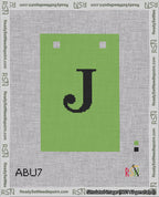 A taped needlepoint canvas with the design: Banner 18 mesh count Squared J Black on Light Green.