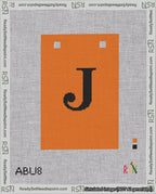 A taped needlepoint canvas with the design: Banner 18 mesh count Squared J Black on Orange.
