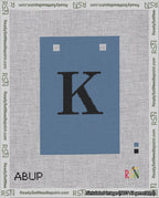 A taped needlepoint canvas with the design: Banner 18 mesh count Squared K Black on Blue.