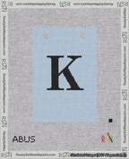 A taped needlepoint canvas with the design: Banner 18 mesh count Squared K Black on Light Blue.