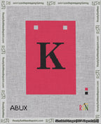 A taped needlepoint canvas with the design: Banner 18 mesh count Squared K Black on Red.