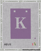 A taped needlepoint canvas with the design: Banner 18 mesh count Squared K White on Purple.