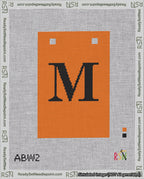 A taped needlepoint canvas with the design: Banner 18 mesh count Squared M Black on Orange.