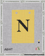 A taped needlepoint canvas with the design: Banner 18 mesh count Squared N Black on Yellow.
