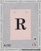 A taped needlepoint canvas with the design: Banner 18 mesh count Squared R Black on Pink.