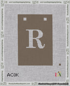A taped needlepoint canvas with the design: Banner 18 mesh count Squared R White on Brown.