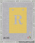 A taped needlepoint canvas with the design: Banner 18 mesh count Squared R White on Yellow.