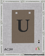 A taped needlepoint canvas with the design: Banner 18 mesh count Squared U Black on Brown.