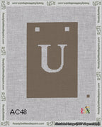 A taped needlepoint canvas with the design: Banner 18 mesh count Squared U White on Brown.