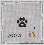A taped needlepoint canvas with the design: Square Cat Paw Print Black On White with Pink Heart.
