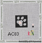 A taped needlepoint canvas with the design: Square Dog Paw Print White on Black with Pink Heart.